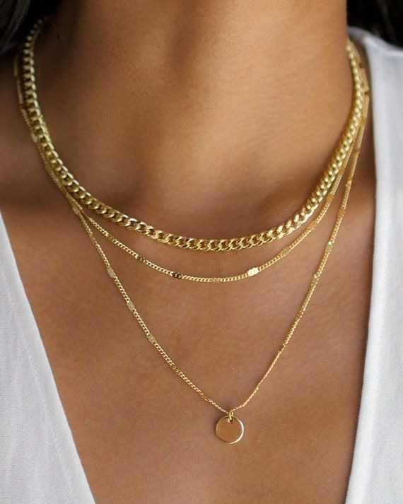 Fyra lagerdelade guldfärgade halsband i olika längder